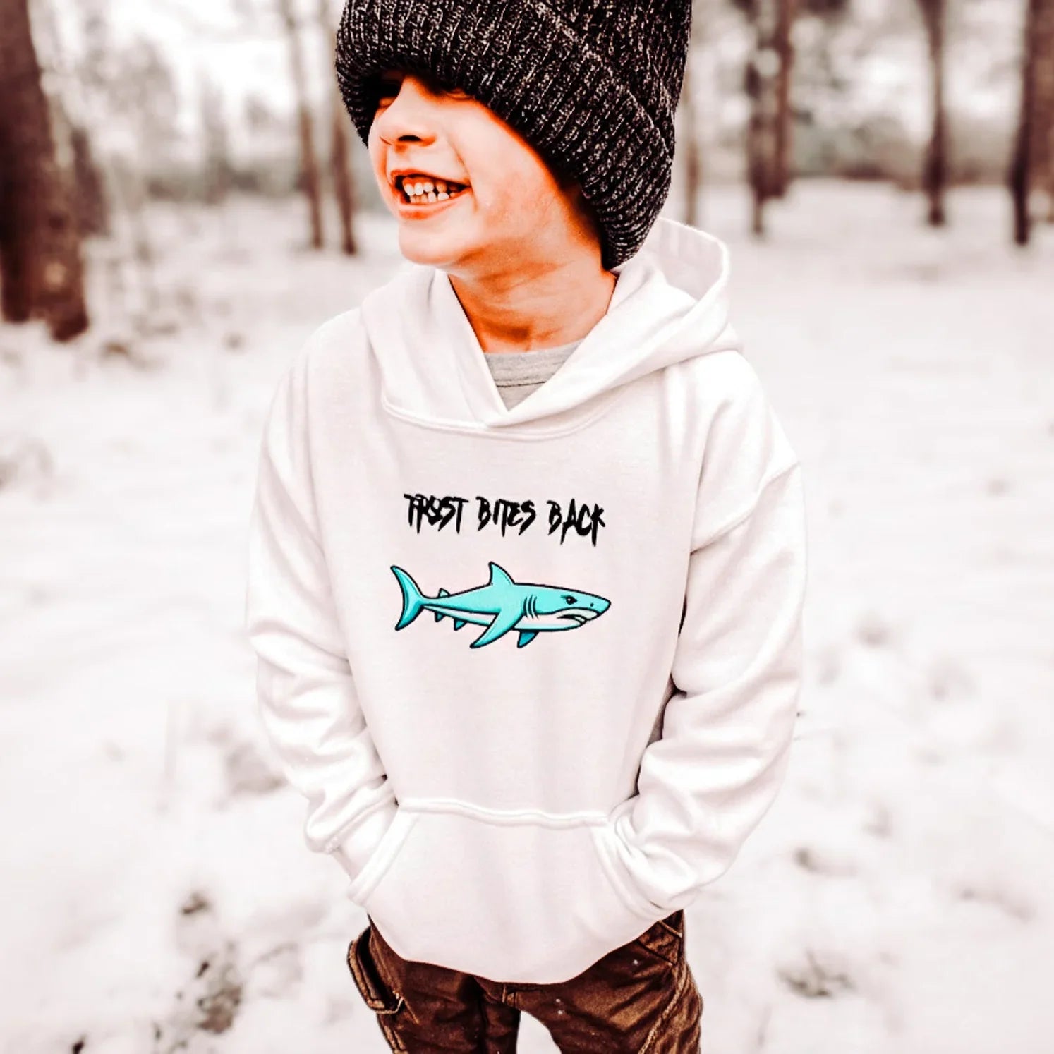 Person wearing a white hoodie with a shark House Panther hoodie and text in a snowy forest