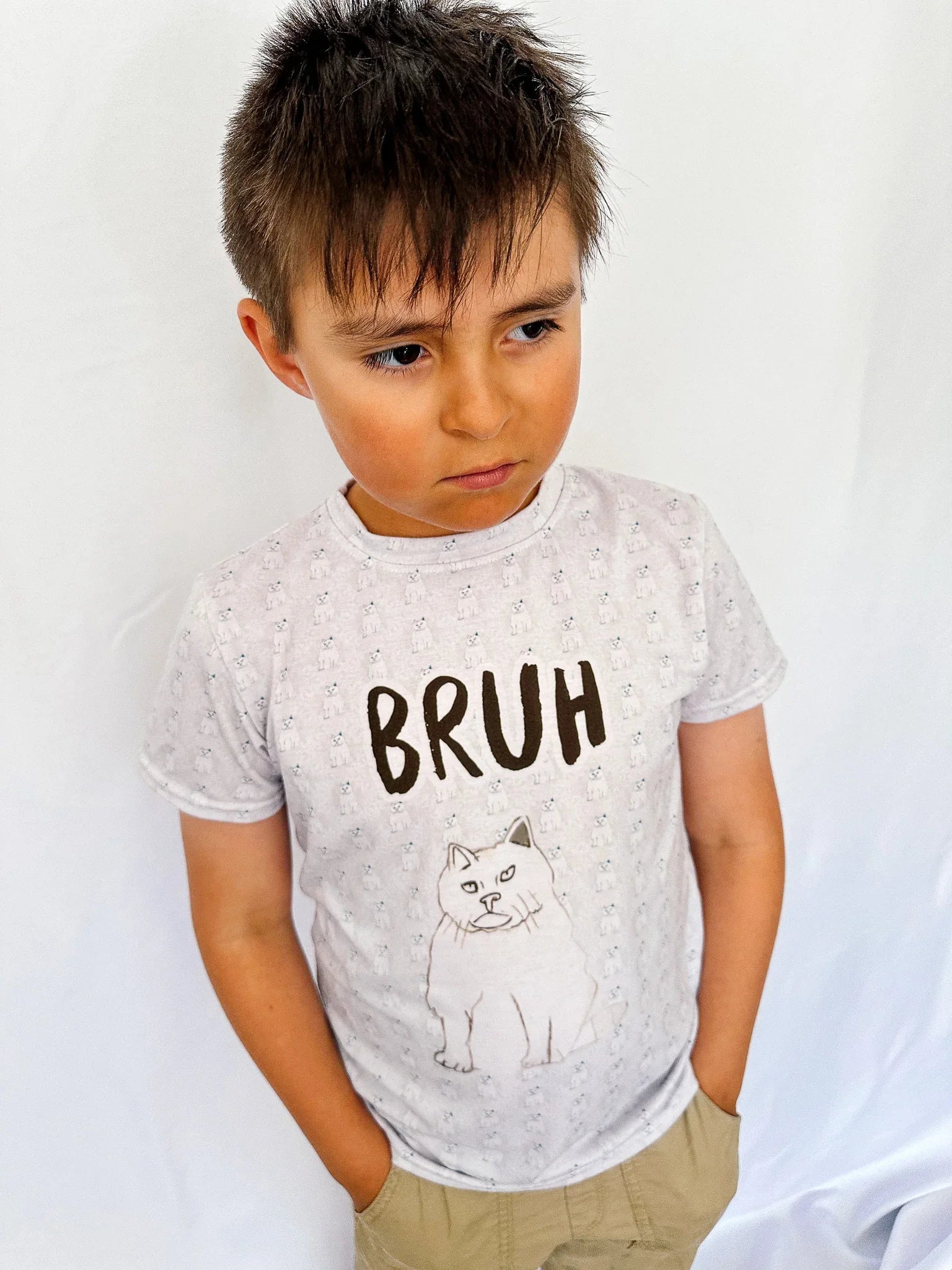Child wearing a t-shirt with 'BRUH' and a cat graphic on a white background